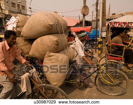 Man pushing load on bicycle in India View Large Photo Image Stock Photo - Man pushing load on bicycle in India. Fotosearch