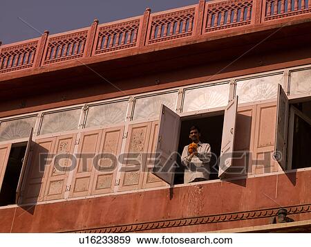 Stock Photo - Man standing at a window in India. Fotosearch