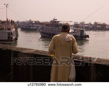 Stock Image - Man standing by riverway in Mumbai India. Fotosearch