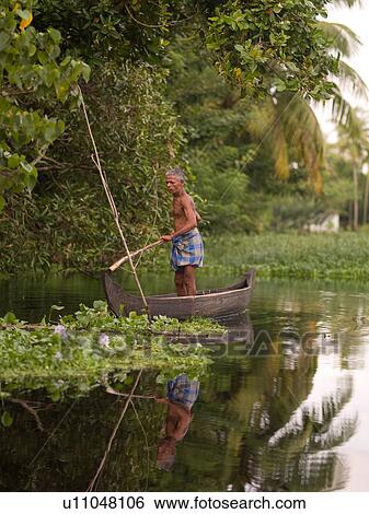 Man standing in a small boat in Inida View Large Photo Image Stock Photograph - Man standing in a small boat in Inida. Fotosearch