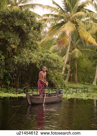 Man standing in boat near lily pads View Large Photo Image Stock Image - Man standing in boat near lily pads. Fotosearch