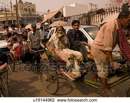 Man with passengers on bicycle in India View Large Photo Image Stock Image - Man with passengers on bicycle in India. Fotosearch
