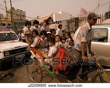 Man with passengers on bicycle in India View Large Photo Image Stock Image - Man with passengers on bicycle in India. Fotosearch