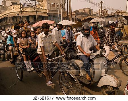 Stock Photo - Man with passengers on bicycle in India. Fotosearch