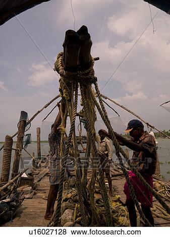 Stock Photo - Men in India pulling on ropes to erect structure. Fotosearch