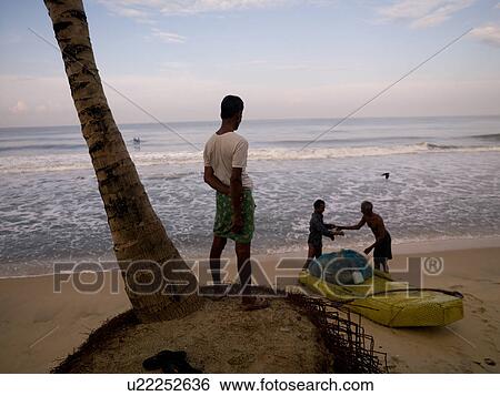 Stock Photograph - People on the beach of the Arabian Sea. Fotosearch