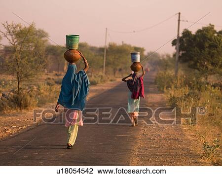 "Rajasthan, India - women balancing containers on their heads" View Large Photo Image Stock Image - "Rajasthan, India - women balancing containers on their heads". Fotosearch