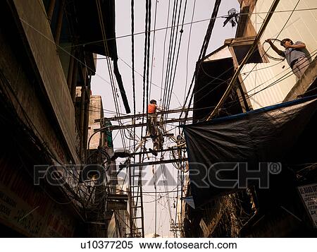 Stock Photography - Repairmen working on overhead wires in Delhi India. Fotosearch
