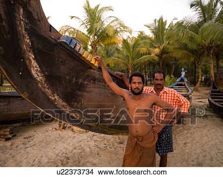Two men standing beside hanging canoe View Large Photo Image Picture - Two men standing beside hanging canoe. Fotosearch