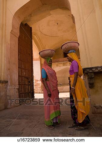 Stock Photo - Two women balancing containers on their heads in India. Fotosearch