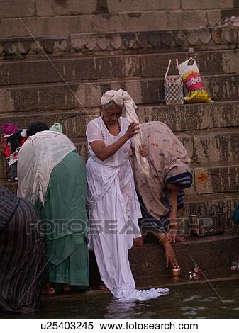 Stock Photography - Woman at the edge of the Ganges River in India. Fotosearch