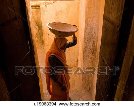 Picture - "Woman carrying large bowl on her head in Amber Fort, Jaipur, India". Fotosearch