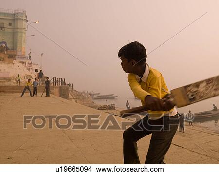 Picture - Young boy in India holding a cricket bat. Fotosearch