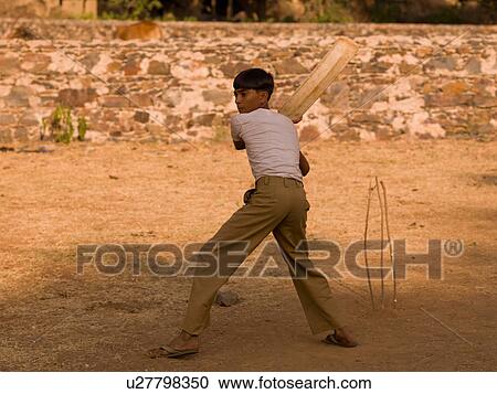 Stock Image - Young boy in India holding a cricket bat. Fotosearch