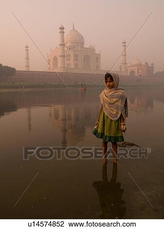 Stock Image - Young girl in India with the Taj Mahal in the background. Fotosearch