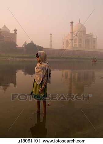 Stock Image - Young girl in India with the Taj Mahal in the background. Fotosearch