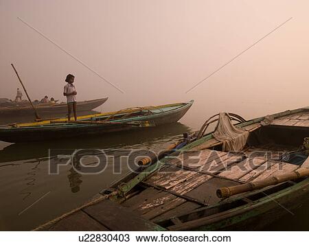 Stock Image - Young girl standing on a boat in India. Fotosearch