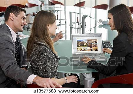 A couple and professional woman at laptop computer View Large Photo Image Stock Photo - A couple and professional woman at laptop computer. Fotosearch