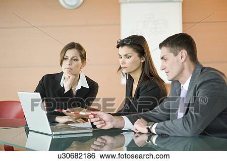 Stock Photograph - Business people looking at laptop. Fotosearch