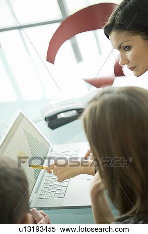 Stock Photography - Business people with laptop showing bar chart. Fotosearch
