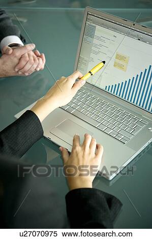 Stock Photography - Business people's hands with laptop showing bar chart. Fotosearch