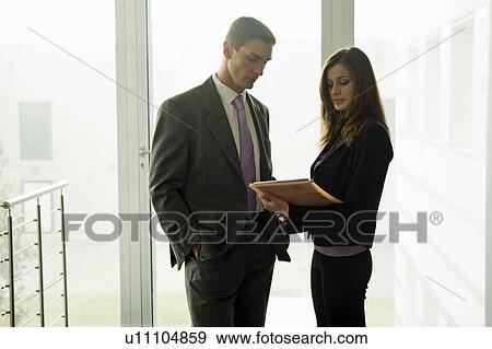 Businessman and businesswoman looking at document View Large Photo Image Stock Photo - Businessman and businesswoman looking at document. Fotosearch