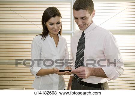 Businessman and businesswoman looking at calculator View Large Photo Image Stock Photo - Businessman and businesswoman looking at calculator. Fotosearch