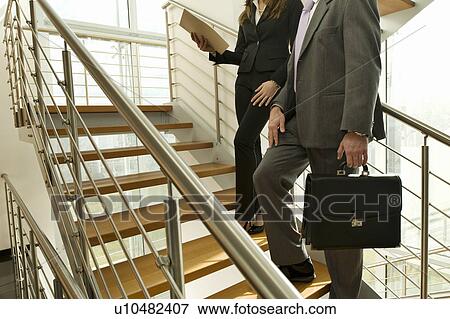 Stock Photo - Businessman and businesswoman on staircase. Fotosearch