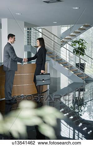 Businessman and woman shaking hands in reception View Large Photo Image Stock Image - Businessman and woman shaking hands in reception. Fotosearch