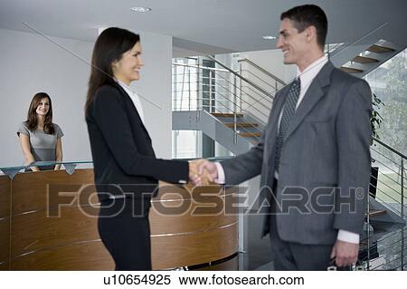 Businessman and woman shaking hands in reception View Large Photo Image Stock Photography - Businessman and woman shaking hands in reception. Fotosearch
