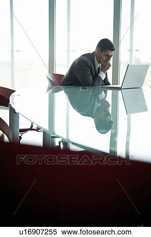 Businessman at laptop computer with his face in his hand View Large Photo Image Stock Photography - Businessman at laptop computer with his face in his hand. Fotosearch