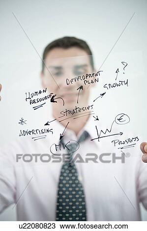 Stock Image - Businessman holding flow chart transparency. Fotosearch