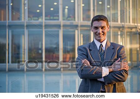 Stock Photograph - Businessman outside of office building. Fotosearch