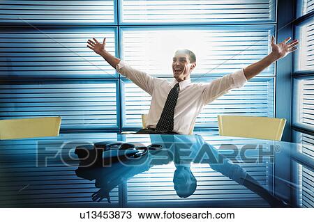 Businessman rejoicing at desk View Large Photo Image Stock Image - Businessman rejoicing at desk. Fotosearch