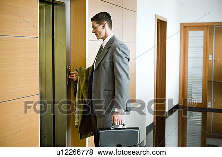 Stock Photo - Businessman waiting for the elevator. Fotosearch