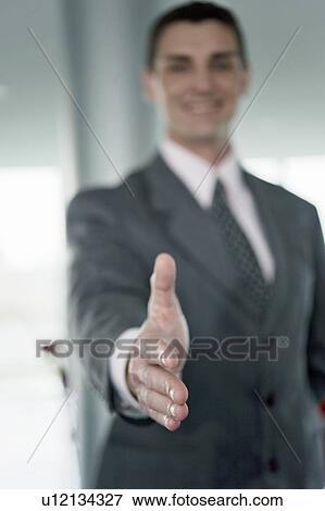 Stock Photo - Businessman with hand out for handshake. Fotosearch