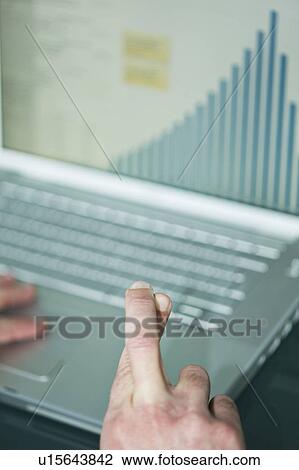 Businessman's fingers crossed at laptop with bar chart View Large Photo Image Stock Image - Businessman's fingers crossed at laptop with bar chart. Fotosearch