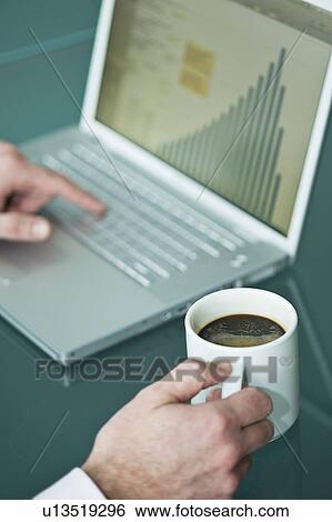 Businessman's hands with coffee cup at laptop with bar chart View Large Photo Image Stock Photograph - Businessman's hands with coffee cup at laptop with bar chart. Fotosearch