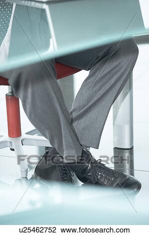 Businessman's legs under desk with laptop View Large Photo Image Stock Image - Businessman's legs under desk with laptop. Fotosearch