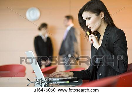 Stock Image - Businesswoman at meeting with laptop. Fotosearch