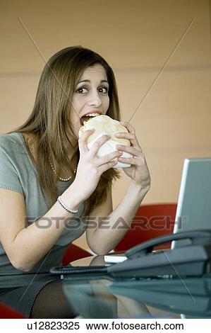 Businesswoman eating pita sandwich at desk View Large Photo Image Stock Photography - Businesswoman eating pita sandwich at desk. Fotosearch