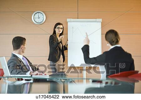 Stock Image - Businesswoman giving a presentation. Fotosearch