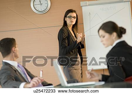 Stock Image - Businesswoman giving a presentation. Fotosearch