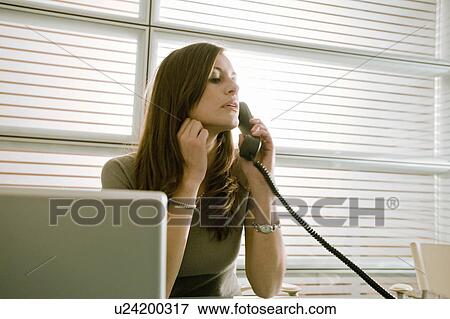 Stock Photo - Businesswoman on telephone at desk. Fotosearch