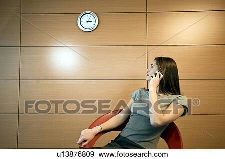 Businesswoman on telephone looking at clock View Large Photo Image Stock Photo - Businesswoman on telephone looking at clock. Fotosearch