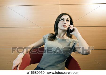 Stock Image - Businesswoman on telephone looking impatient. Fotosearch