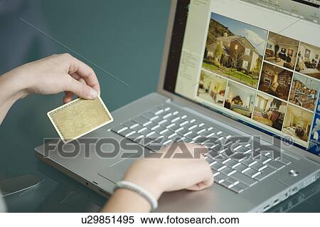 Businesswoman's hands holding credit card at laptop View Large Photo Image Stock Photography - Businesswoman's hands holding credit card at laptop. Fotosearch