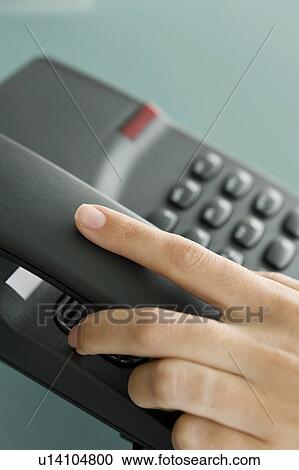 Stock Image - Closeup of woman's hand on telephone. Fotosearch
