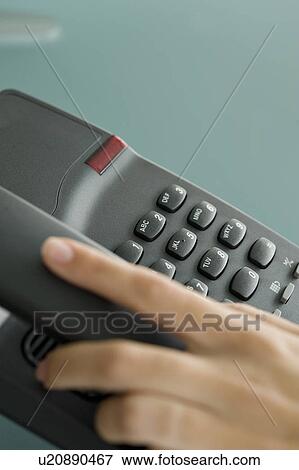 Stock Photo - Closeup of woman's hand on telephone. Fotosearch