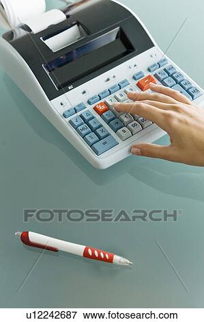 Stock Photo - Closeup of woman's hand using calculator. Fotosearch